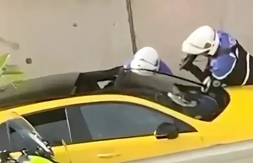 Policemen pointing gun at Nael M car